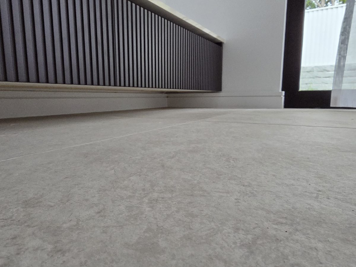 Before, LED off: dark fluted living joinery from floor level, Picnic Point duplex